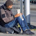 Hombre joven mendigando sentado