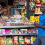 Hombre africano delante de un kiosko