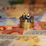 Dos ancianos sentados en unas monedas