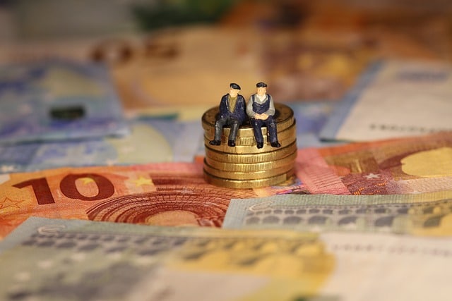 Dos ancianos sentados en unas monedas